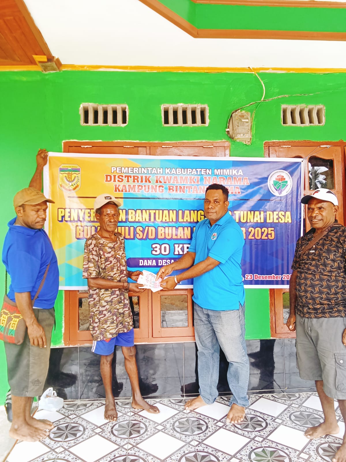 Salah satu aparatur kampung bersama Kepala Kampung Bintang Lima, Marthinus Kogoya saat menyerahkan BLT kepada seorang warga 