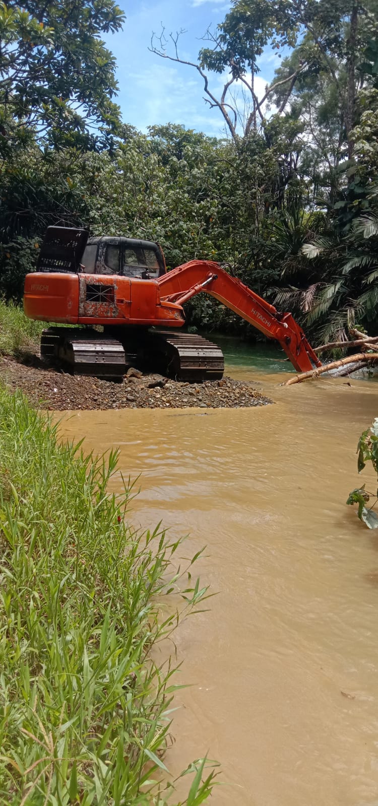 Alat berat saat mengangkat material dari dalam sungai