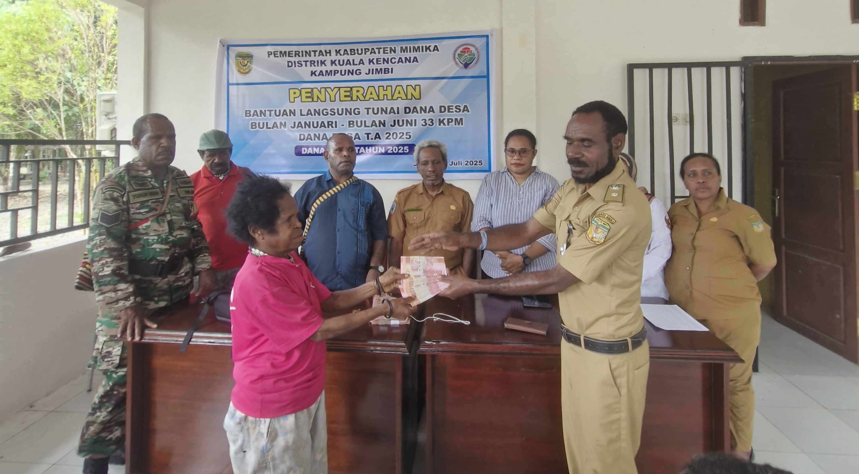 Kepala Kampung Jimbi Litenus Kogoya didampingi bendahara Kampung Jimbi Dianus Kogoya didampingi pendamping desa dan Babinsa saat menyerahkan bantuan langsung tunai kepada warga
