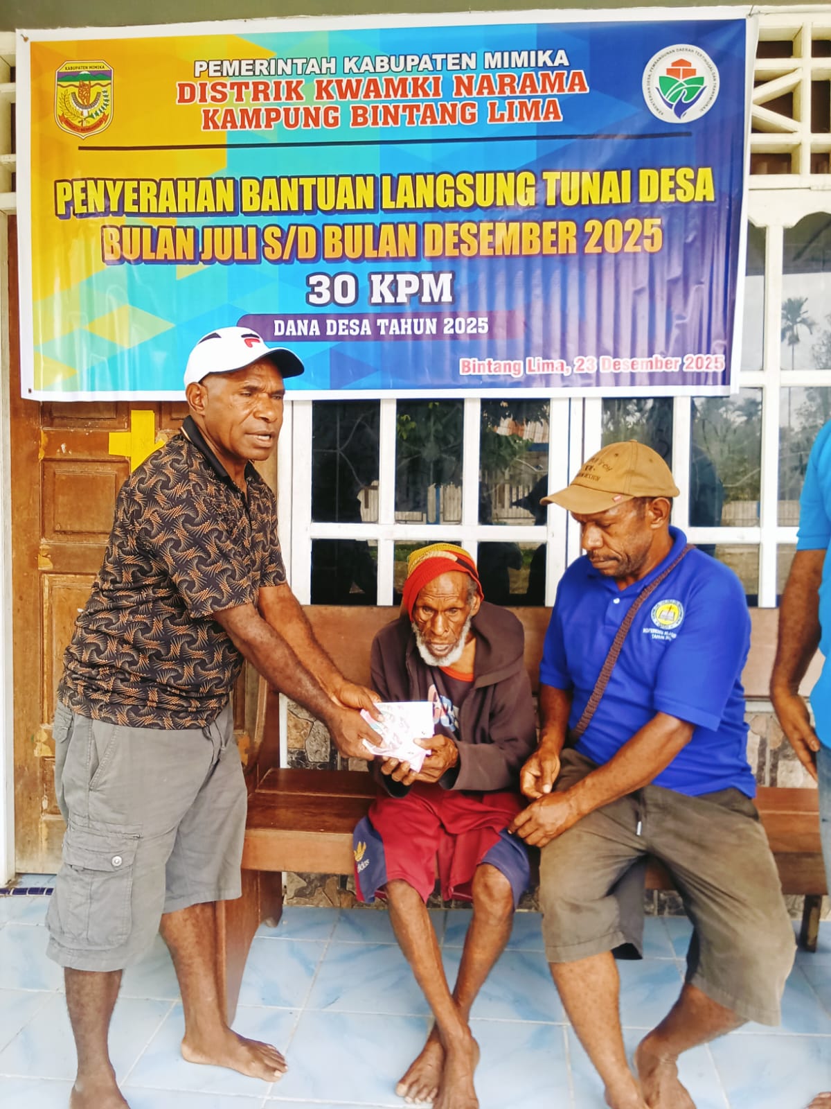 Kepala Kampung Bintang Lima, Marthinus Kogoya saat menyerahkan BLT kepada seorang warga 