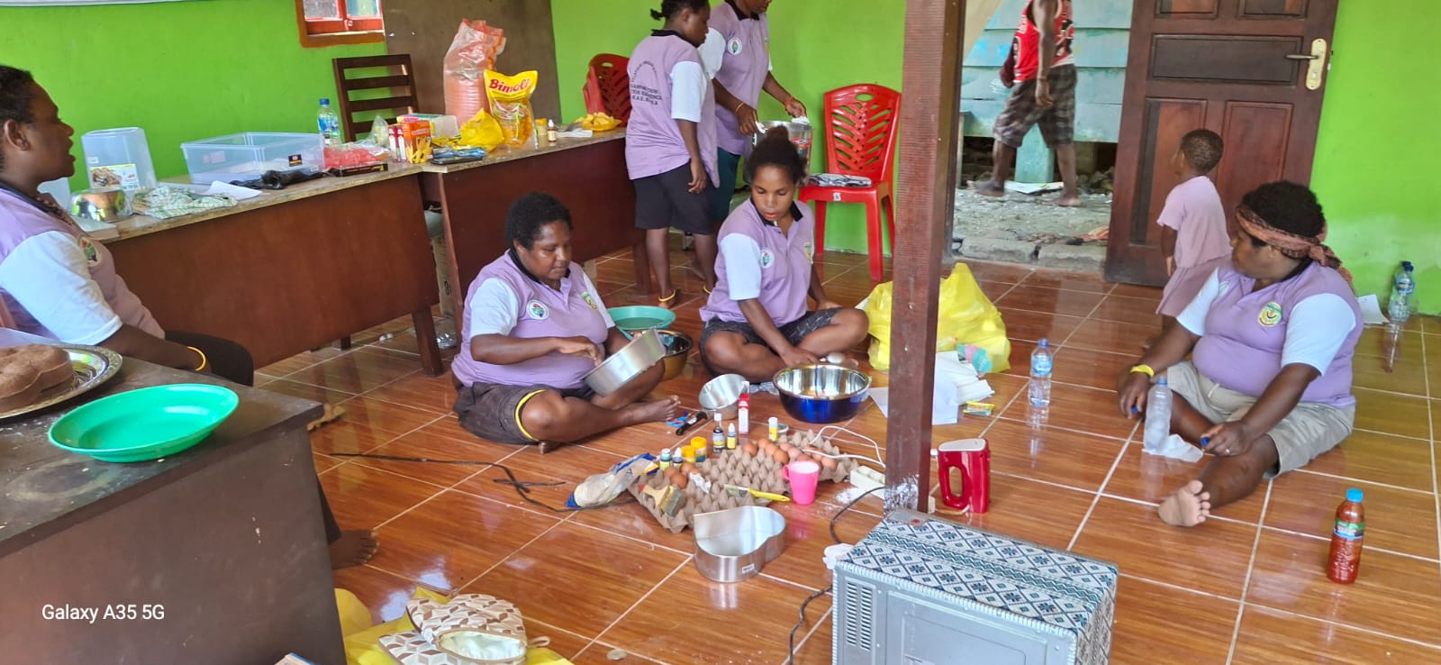 Ibu-ibu kader Posyandu saat mempersiapkan bahan kue kemudian membuat adonan kue