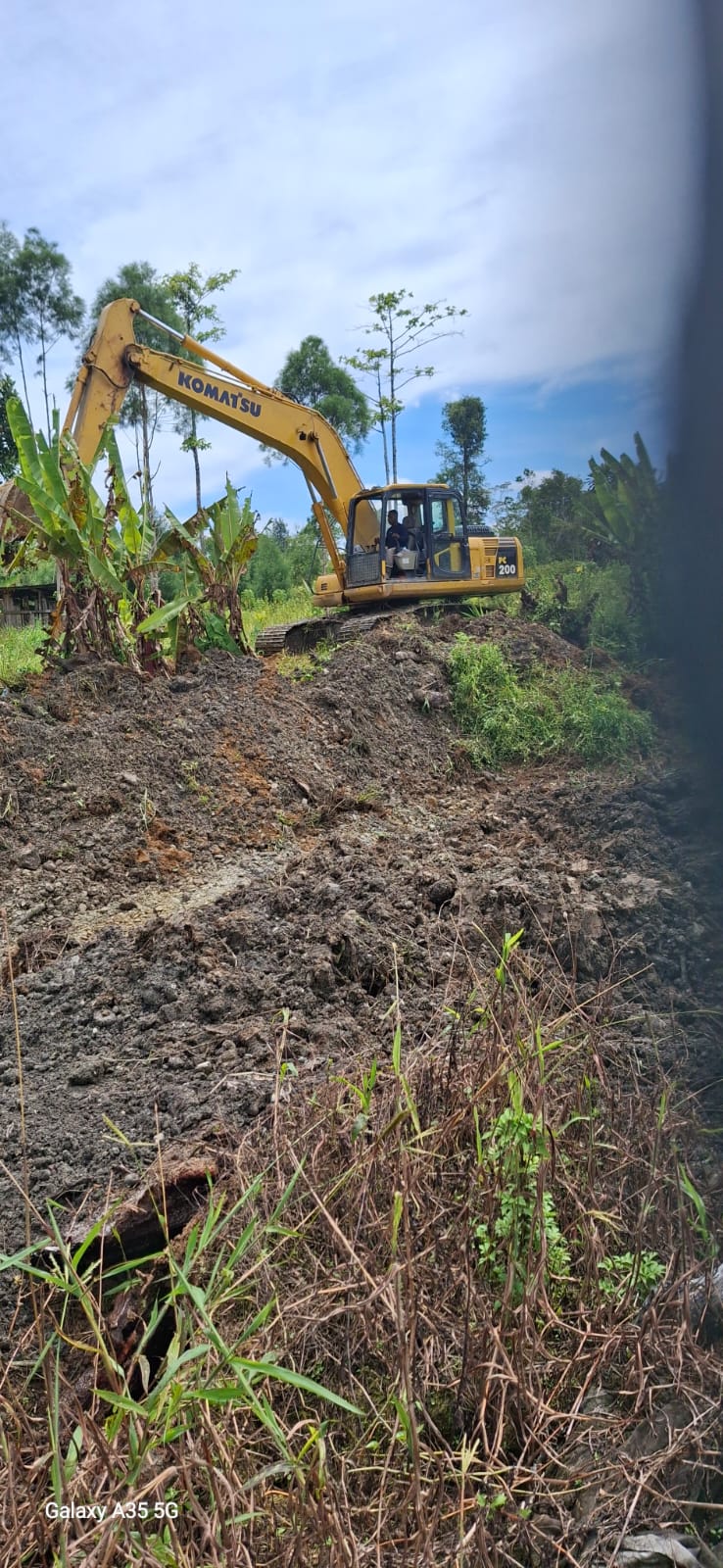 Excavator sedang menimbun jalan