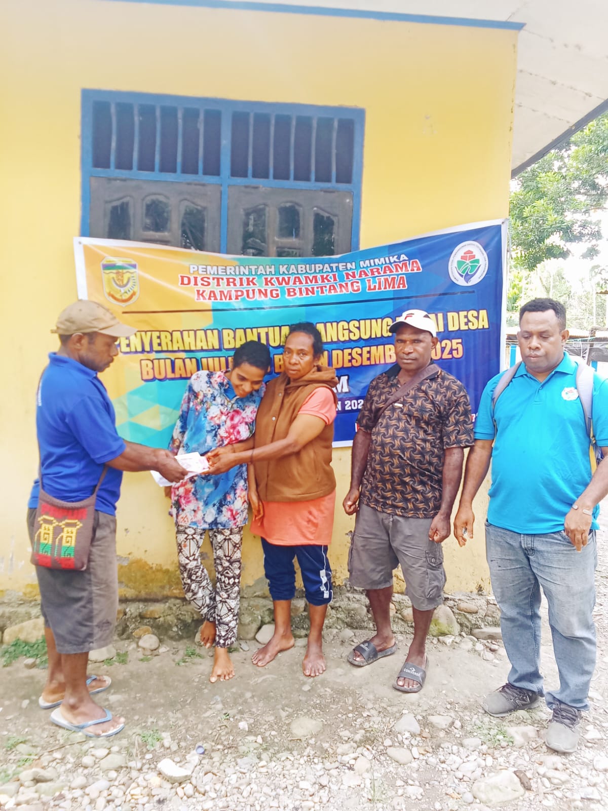 Salah satu aparatur kampung bersama Kepala Kampung Bintang Lima, Marthinus Kogoya saat menyerahkan BLT kepada seorang warga 