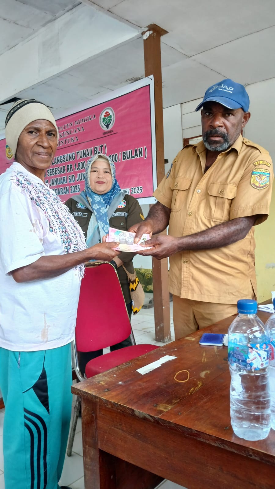 Kaur Kesra Kampung Bhintuka Derpen Tabuni saat menyerahkan bantuan langsung tunai kepada warga