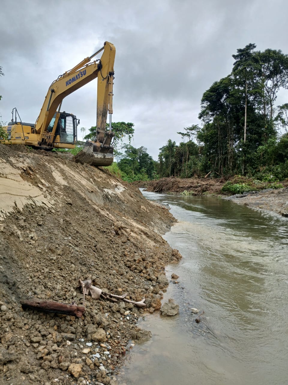 Excavator saat mengangkat material dari dalam sungai