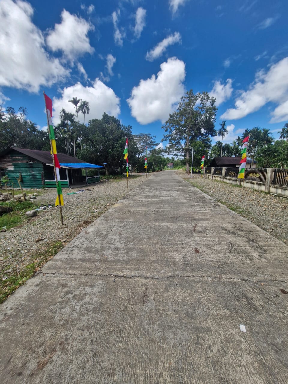 Suasana jalan masuk Kampung Jimbi yang sudah terpasang umbul-umbul dan bendera