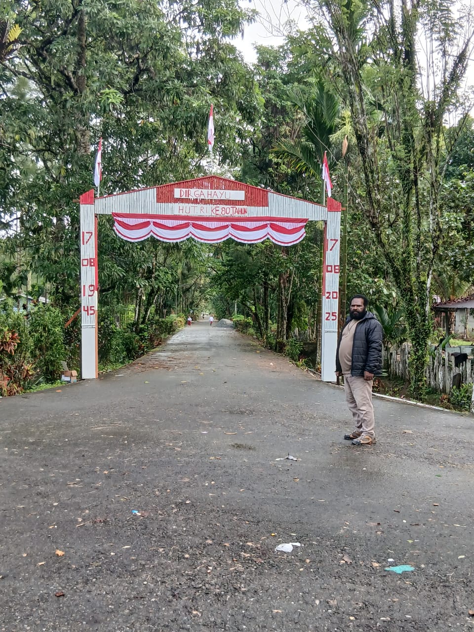 Kepala Kampung Utikini I Luther Karagainal saat berada didepan gapura yang telah selesai dibuat