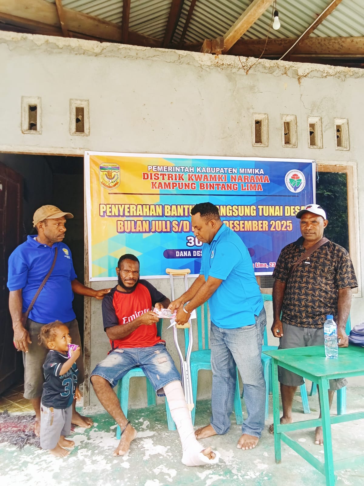 Salah satu aparatur kampung bersama Kepala Kampung Bintang Lima, Marthinus Kogoya saat menyerahkan BLT kepada seorang warga 