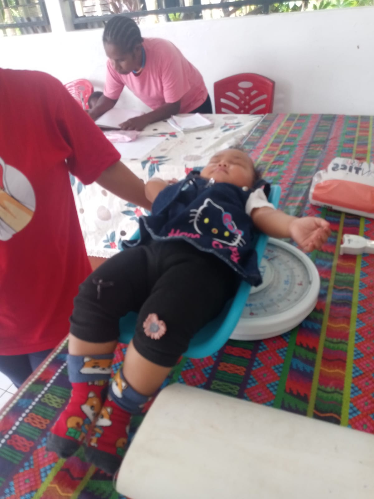 Bayi yang sedang ditimbang berat badannya 