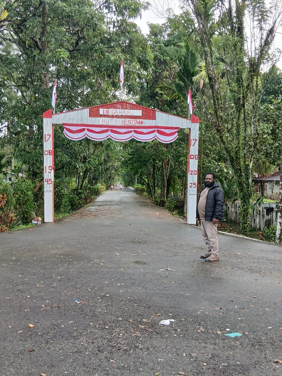 Kepala Kampung Utikini I Luther Karagainal saat berada didepan gapura yang telah selesai dibuat