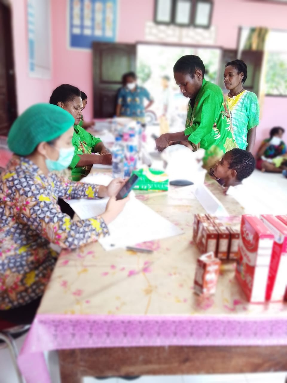 Para tenaga kesehatan saat melayani ibu-ibu yang membawa anak-anaknya untuk mendapatkan pelayanan kesehatan 