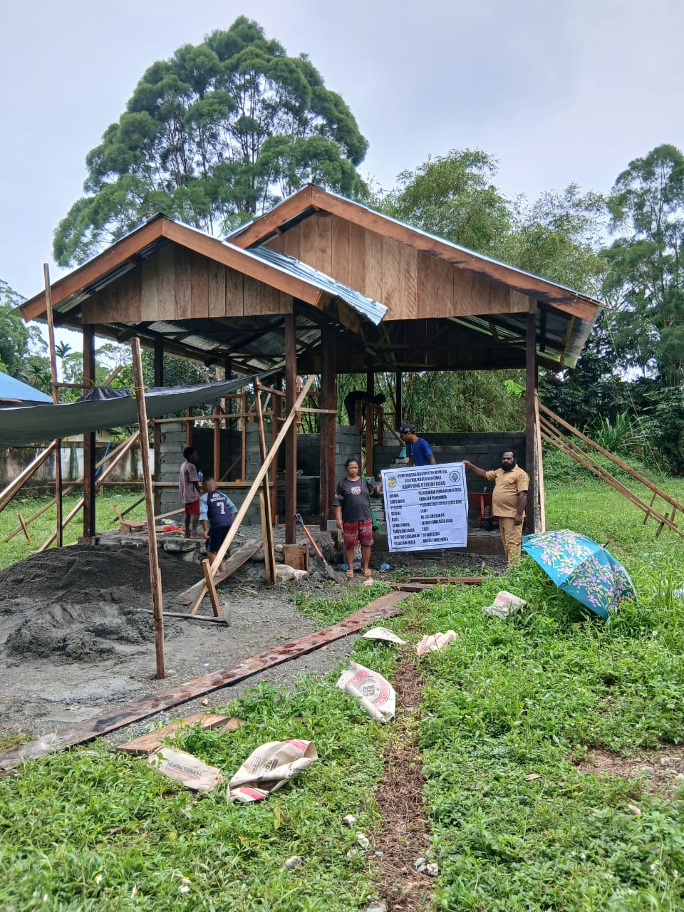 Kepala Kampung Utikini I, Luther Karagainal saat foto didepan rumah layak Huni yang sedang dibangun