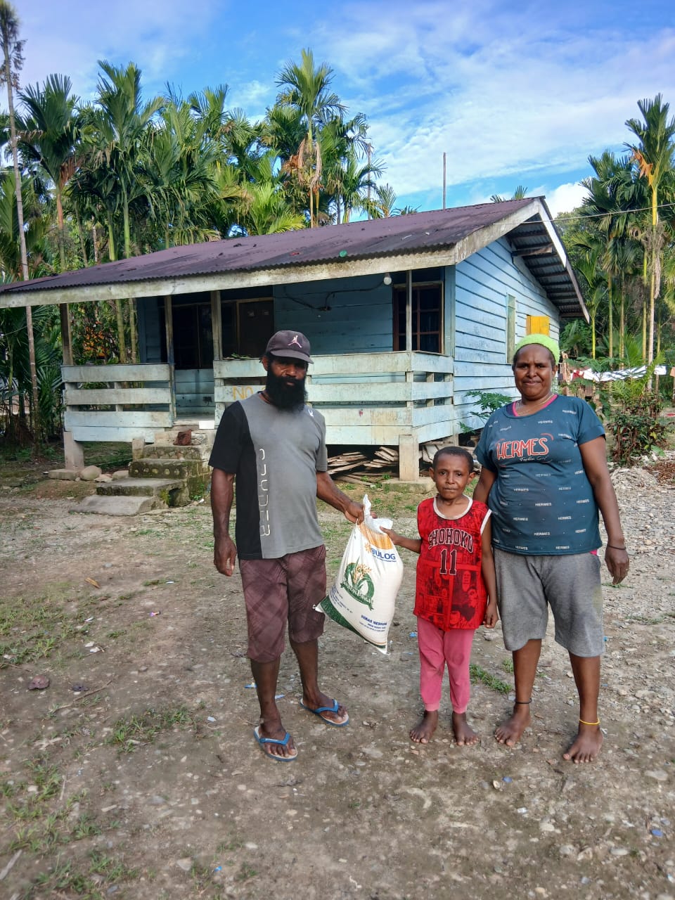 Aparatur Kampung Utikini I saat menyerahkan bantuan beras kepada warga