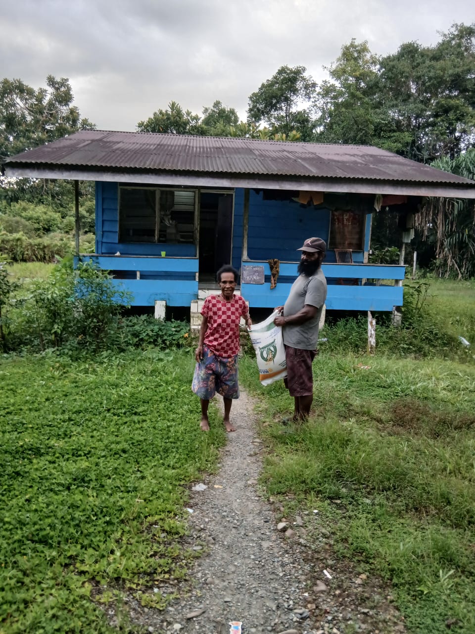 Aparatur Kampung Utikini I saat menyerahkan bantuan beras kepada warga