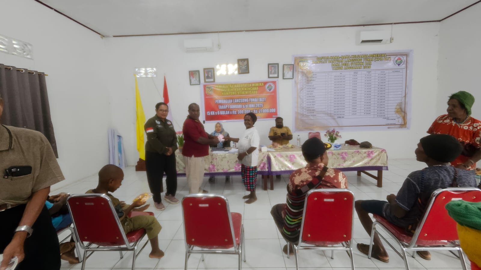 Aparatur kampung Utikini Satu saat menyerahkan BLT kepada salah seorang warga KPM disaksikan pendamping desa dan aparatur kampung 
