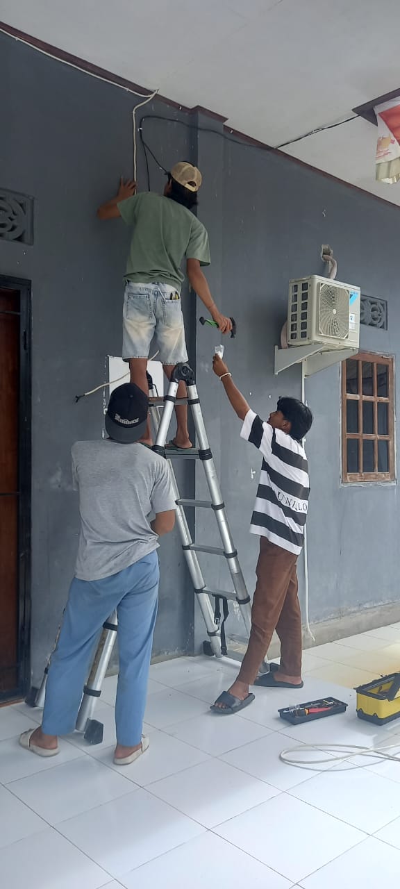 Proses pemasangan AC di Aula Kampung Utikini I