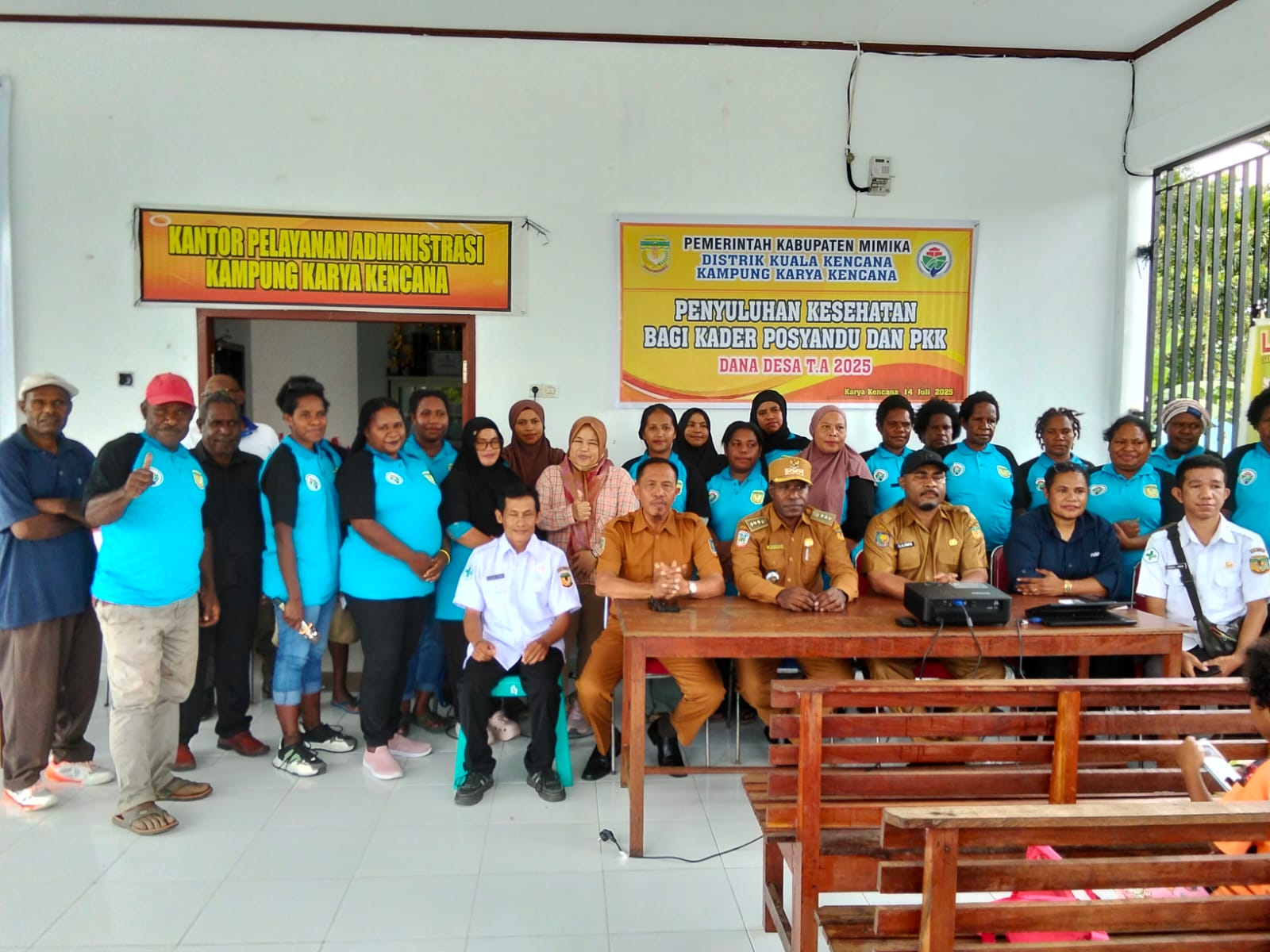 Foto bersama Plt Kepala Kampung Karya Kencana, Rakam Suntoro, Kepala Distrik Kuala Kencana, Yemi Gobai, Kabid Pemerintahan Kampung, Frits Werimon, dan Tenaga Ahli Pemberdayaan Masyarakat Desa, aparatur Kampung dan ibu-ibu kader Posyandu dan PKK
