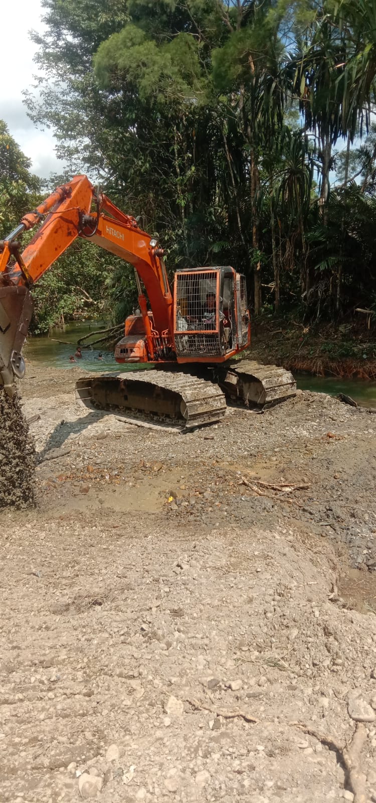 Alat berat saat mengangkat material dari dalam sungai