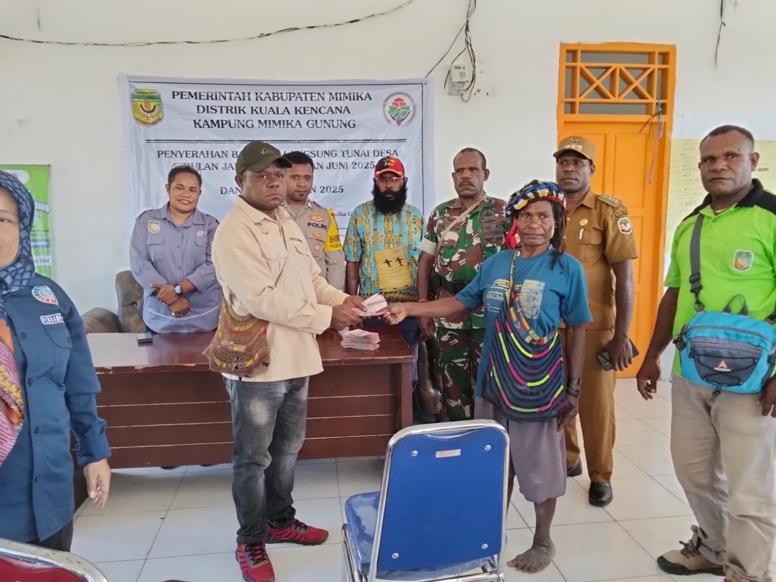 Kepala Kampung Mimika Gunung Primus Kobogau saat menyerahkan bantuan langsung tunai kepada warga