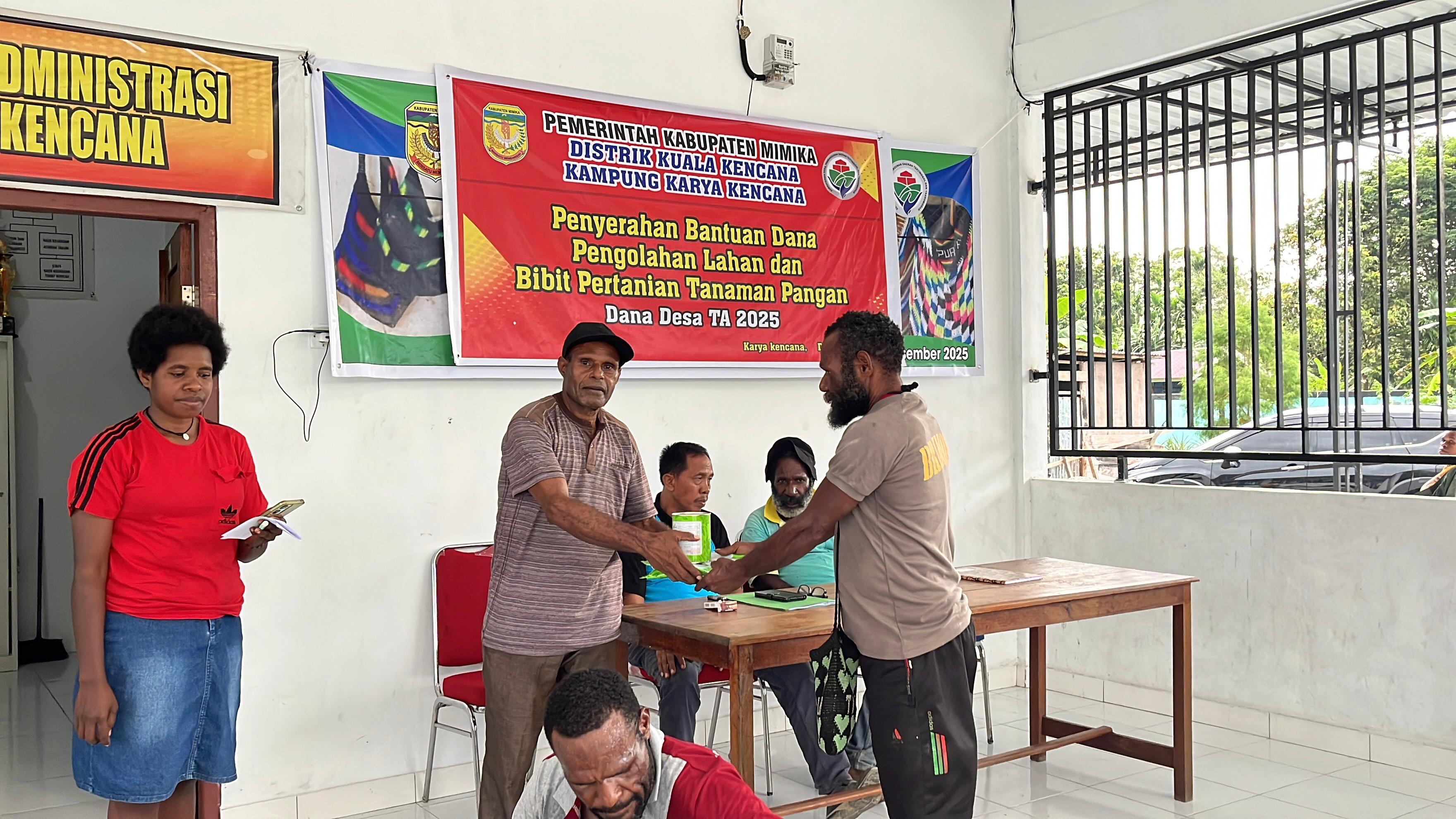 Salah satu aparatur Kampung di Kampung Karya Kencana saat menyerahkan bantuan kepada warga disaksikan oleh Kepala Kampung Karya Kencana Rakam Suntoro 