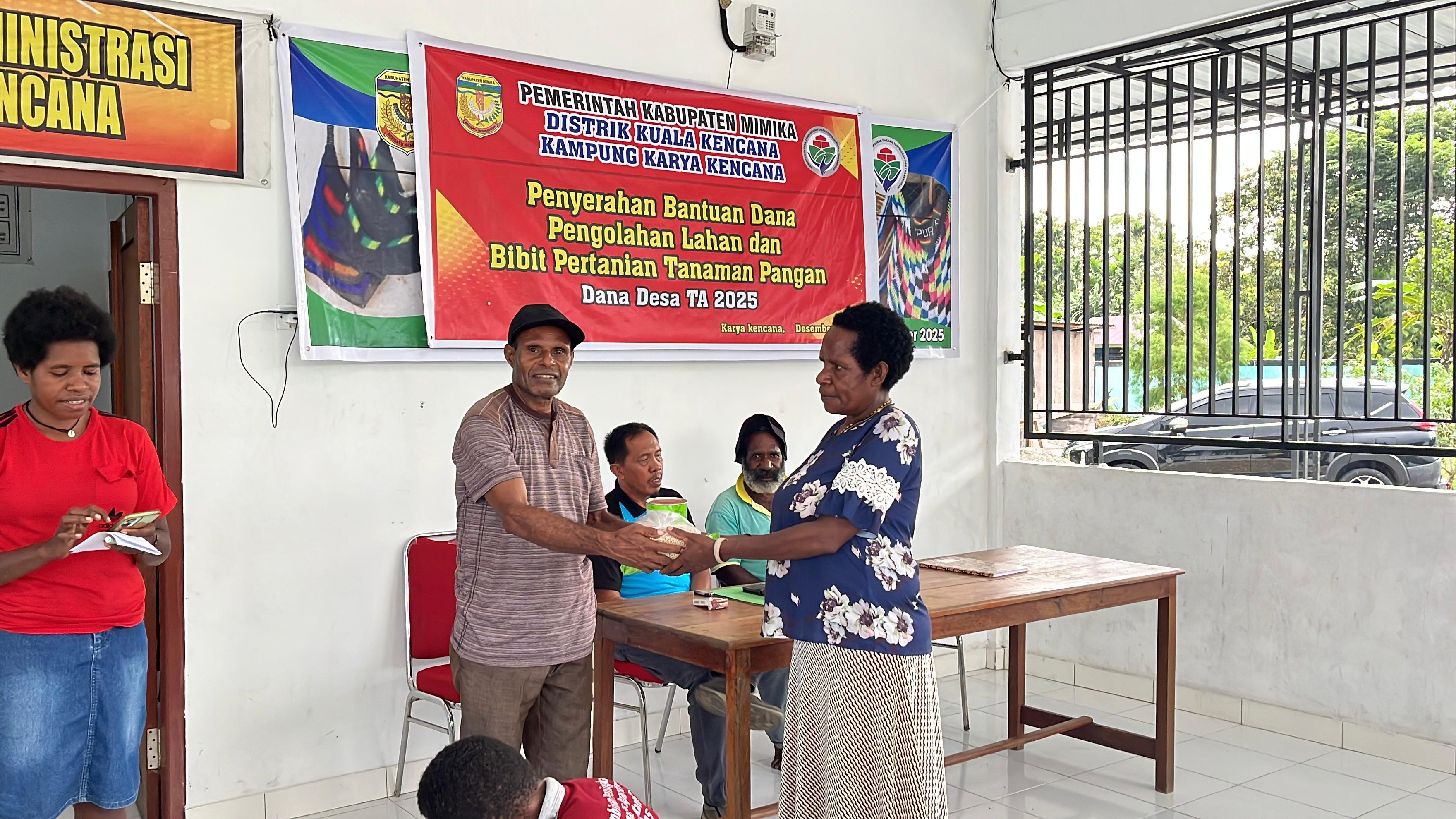Salah satu aparatur pemerintah di Kampung Karya Kencana saat menyerahkan bantuan kepada warga disaksikan oleh Kepala Kampung Karya Kencana Rakam Suntoro 