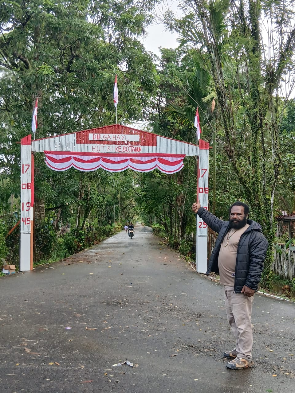 Kepala Kampung Utikini I Luther Karagainal saat berada didepan gapura yang telah selesai dibuat
