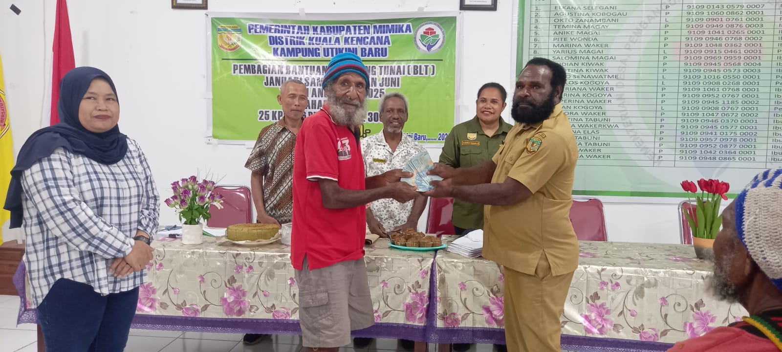 Kepala Kampung Utikini Satu, Luther Karagainal saat menyerahkan Bantuan Langsung Tunai kepada warga