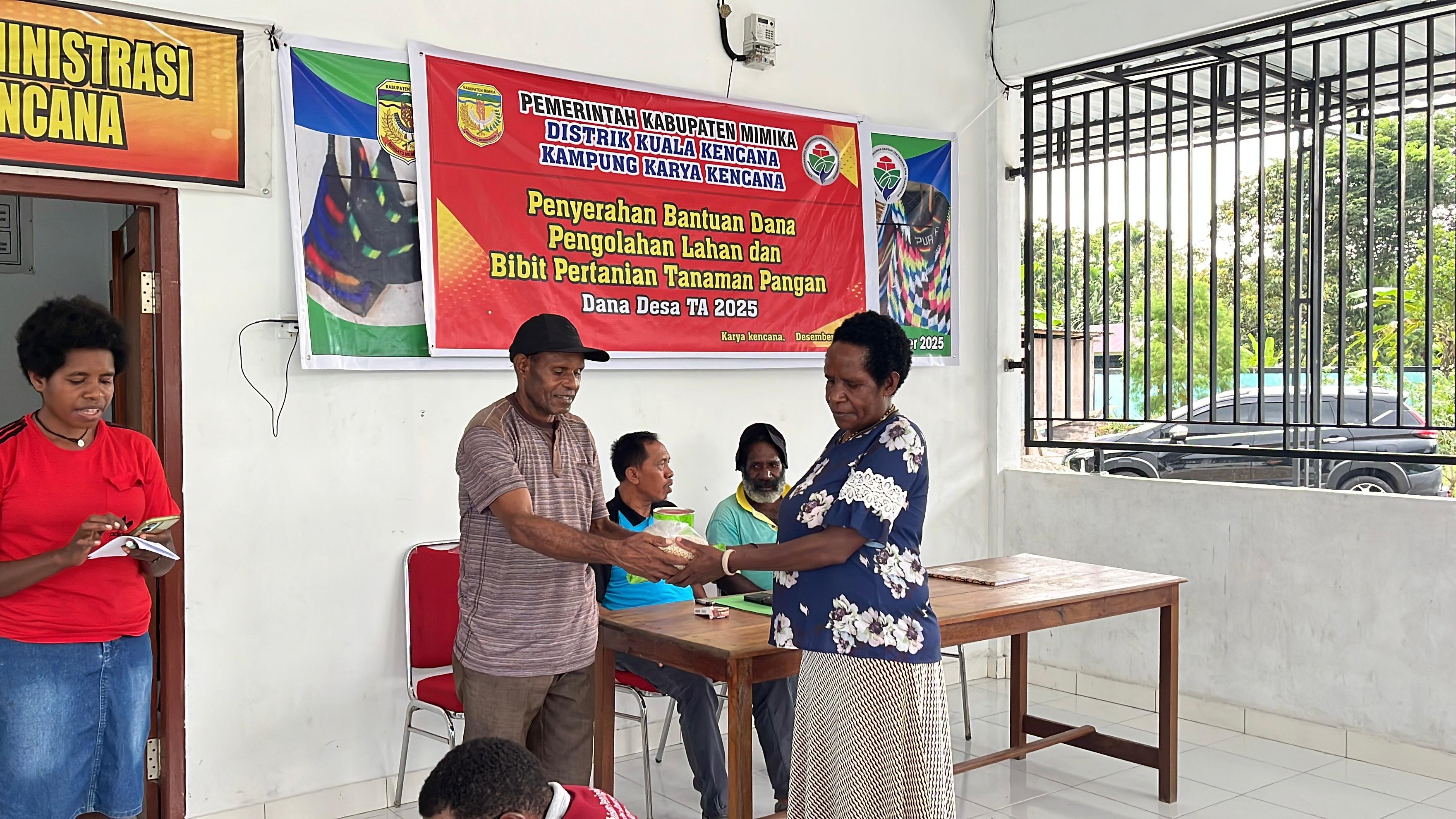 Salah satu aparatur pemerintah di Kampung Karya Kencana saat menyerahkan bantuan kepada warga disaksikan oleh Kepala Kampung Karya Kencana Rakam Suntoro 