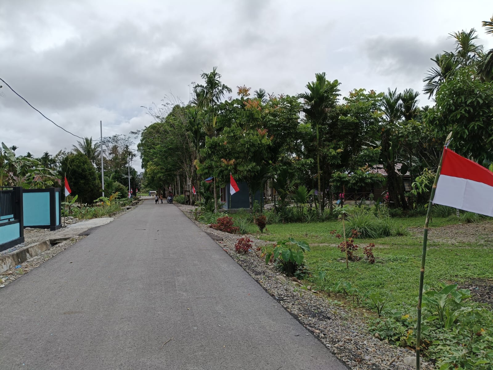 Warga saat menancap tiang bendera merah putih didepan rumah warga