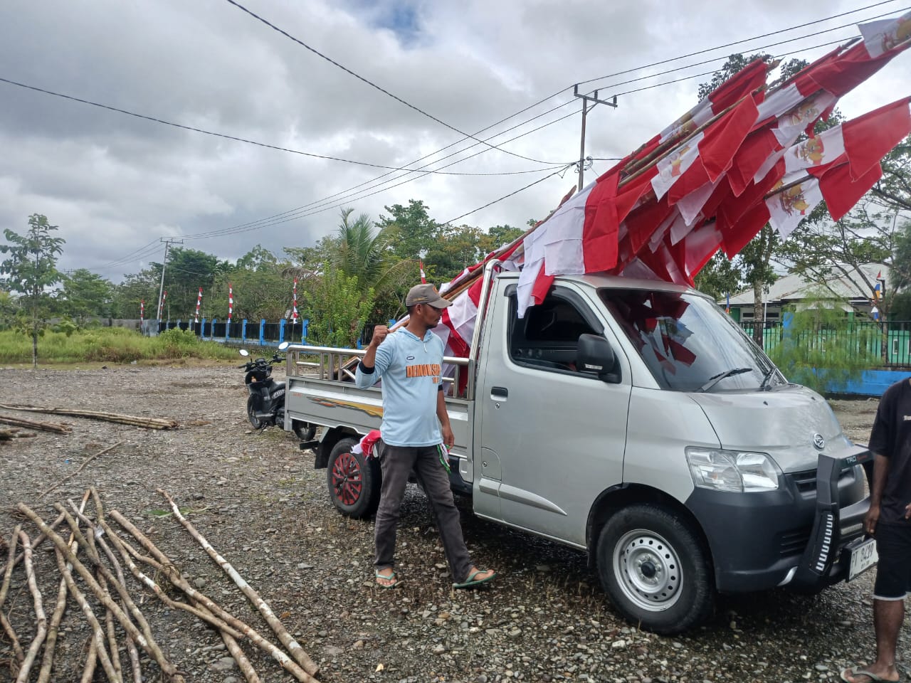 Warga sedang mengangkut bendera merah putih untuk dipasang
