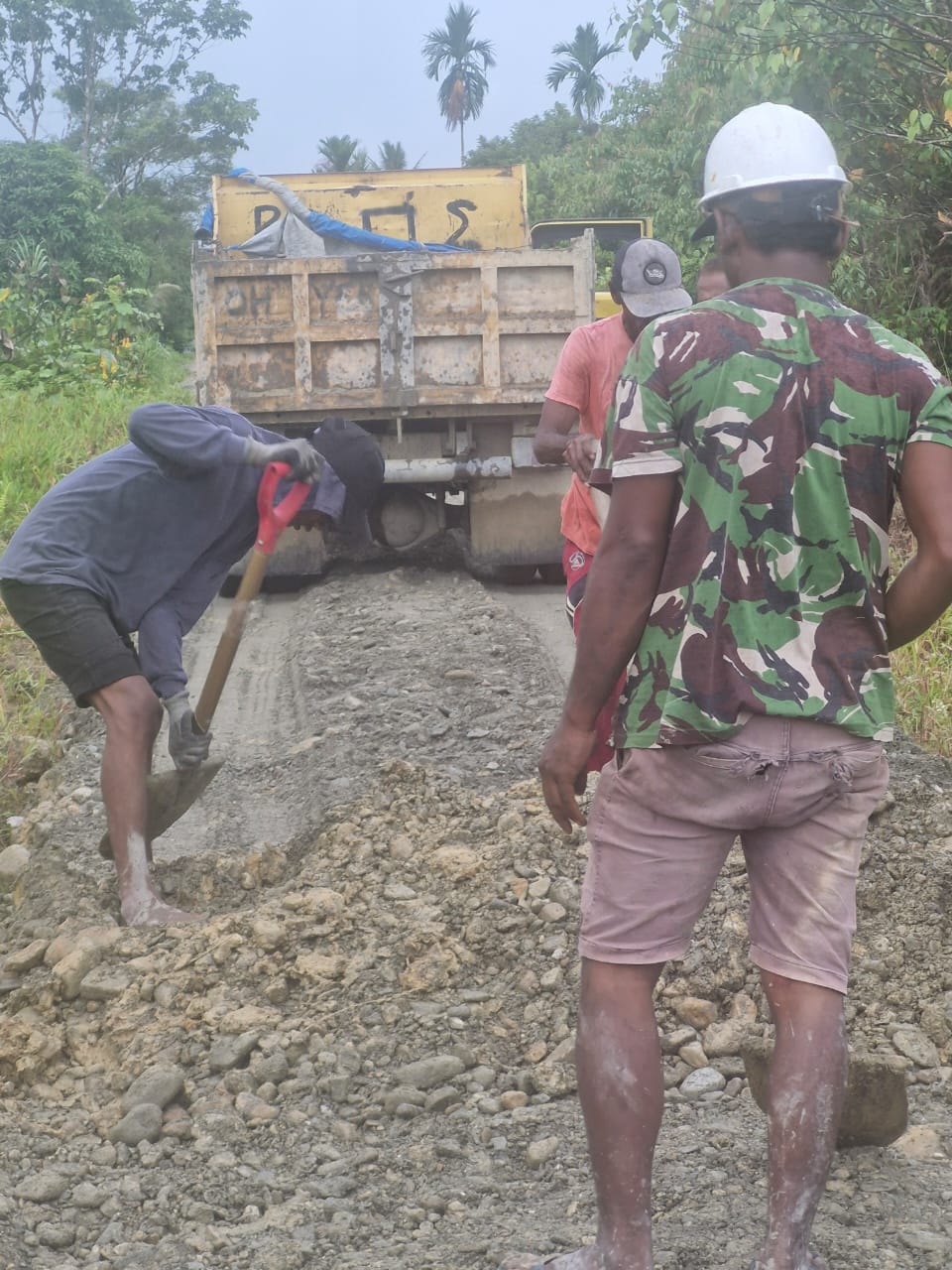 Warga Kampung Jimbi saat merapikan material untuk penimbunan jalan