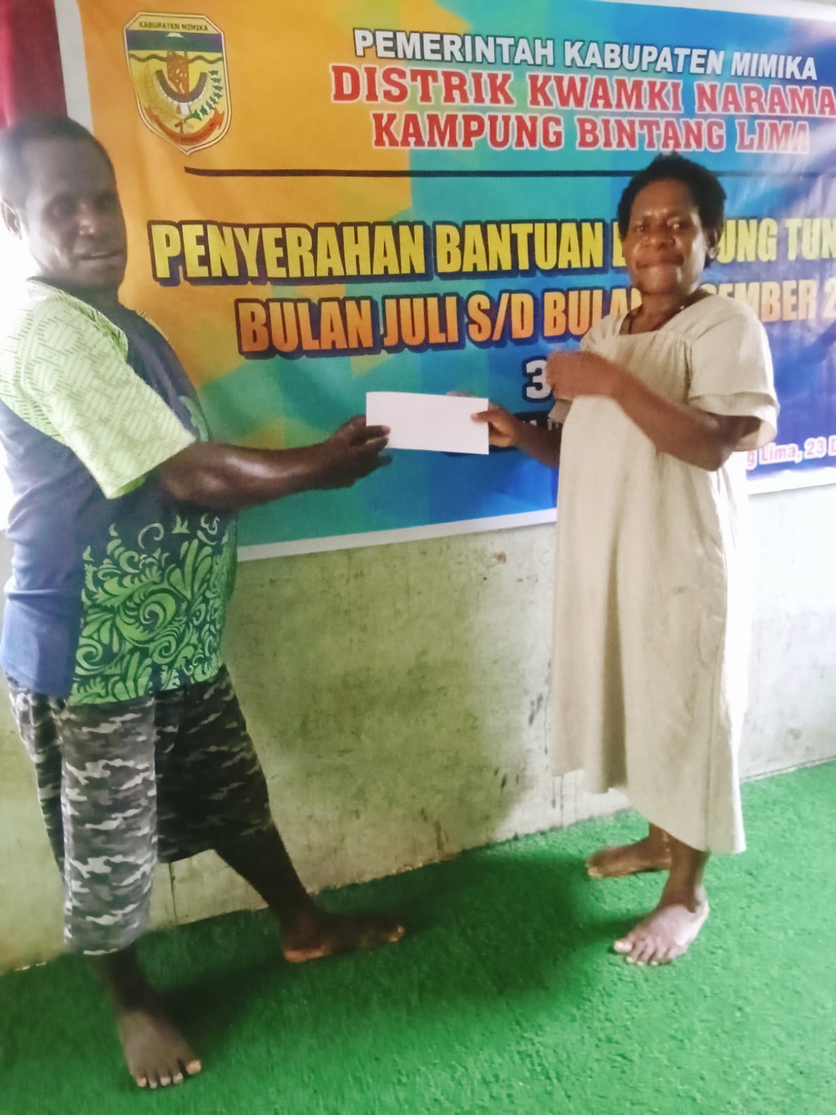 Salah satu aparatur kampung bersama Kepala Kampung Bintang Lima, Marthinus Kogoya saat menyerahkan BLT kepada seorang warga 