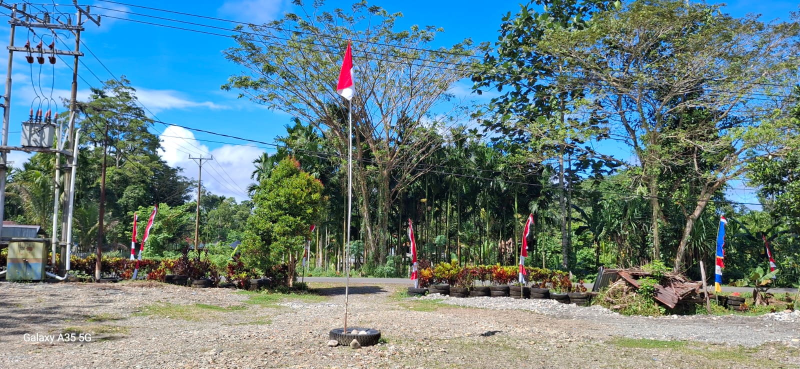 Suasana didepan Kantor Kampung Utikini II setelah pemasangan bendera merah putih dan umbul-umbul