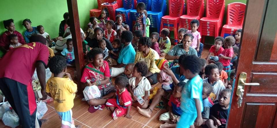 Ibu-ibu dan anak-anak saat menerima bingkisan makanan tambahan