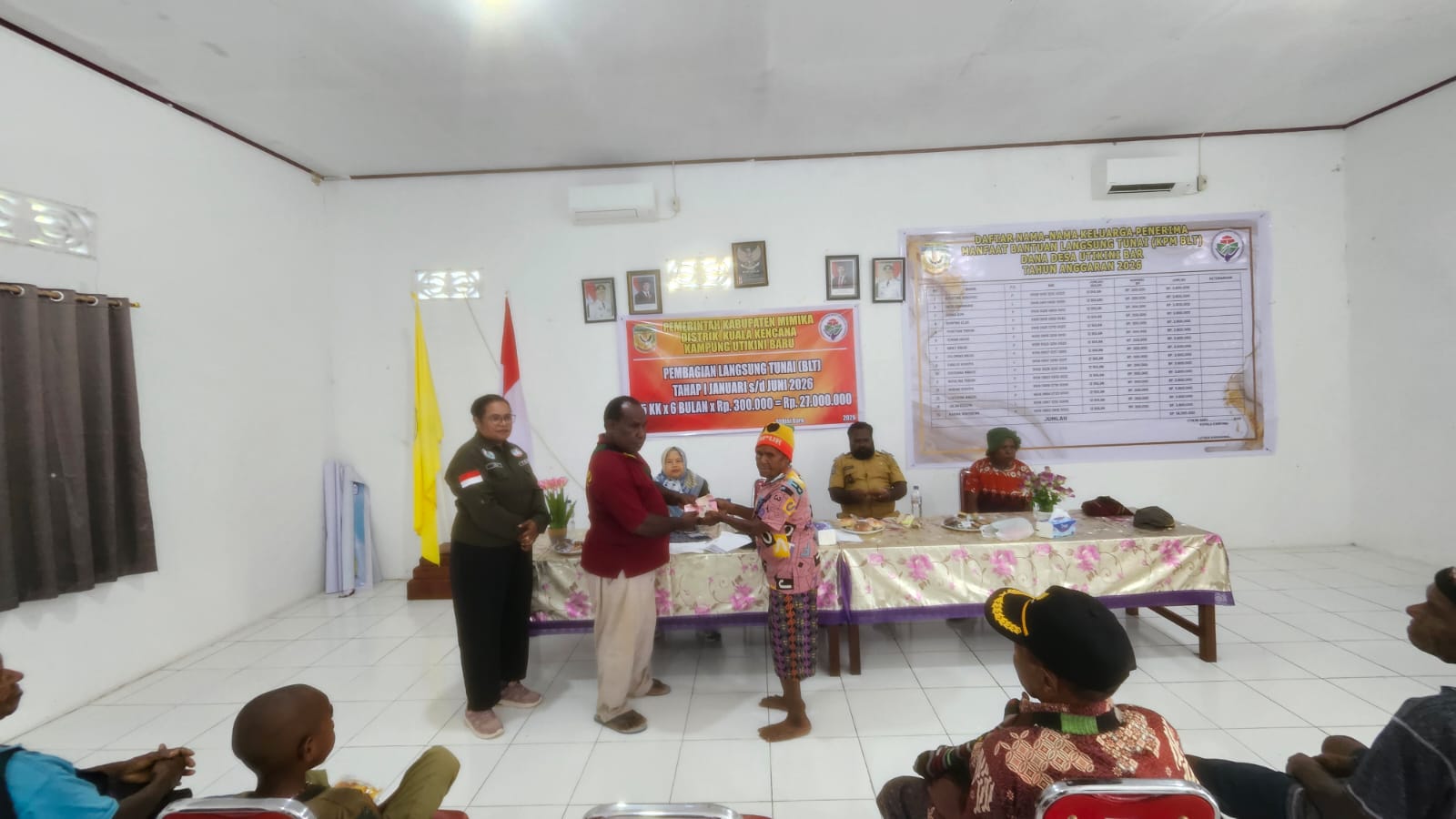 Salah satu aparatur kampung saat menyerahkan BLT kepada salah seorang warga KPM disaksikan pendamping desa dan aparatur kampung 