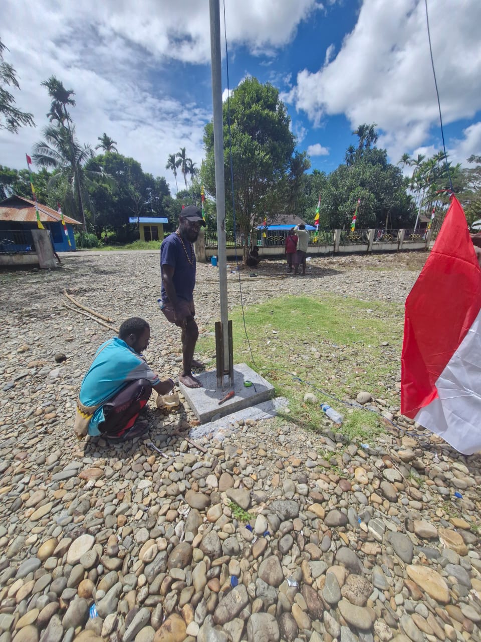 Warga saat menguatkan posisi tiang bendera