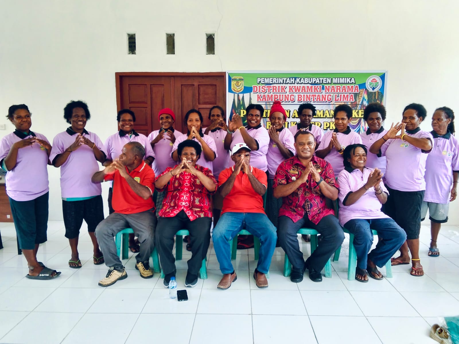 Kepala Distrik Kwamki Narama Edwin Habuebi bersama Kepala Kampung Bintang Lima Marthinus Kogoya dan kader posyandu saat foto bersama dengan posisi tangan membentuk Mimika Rumah Kita 