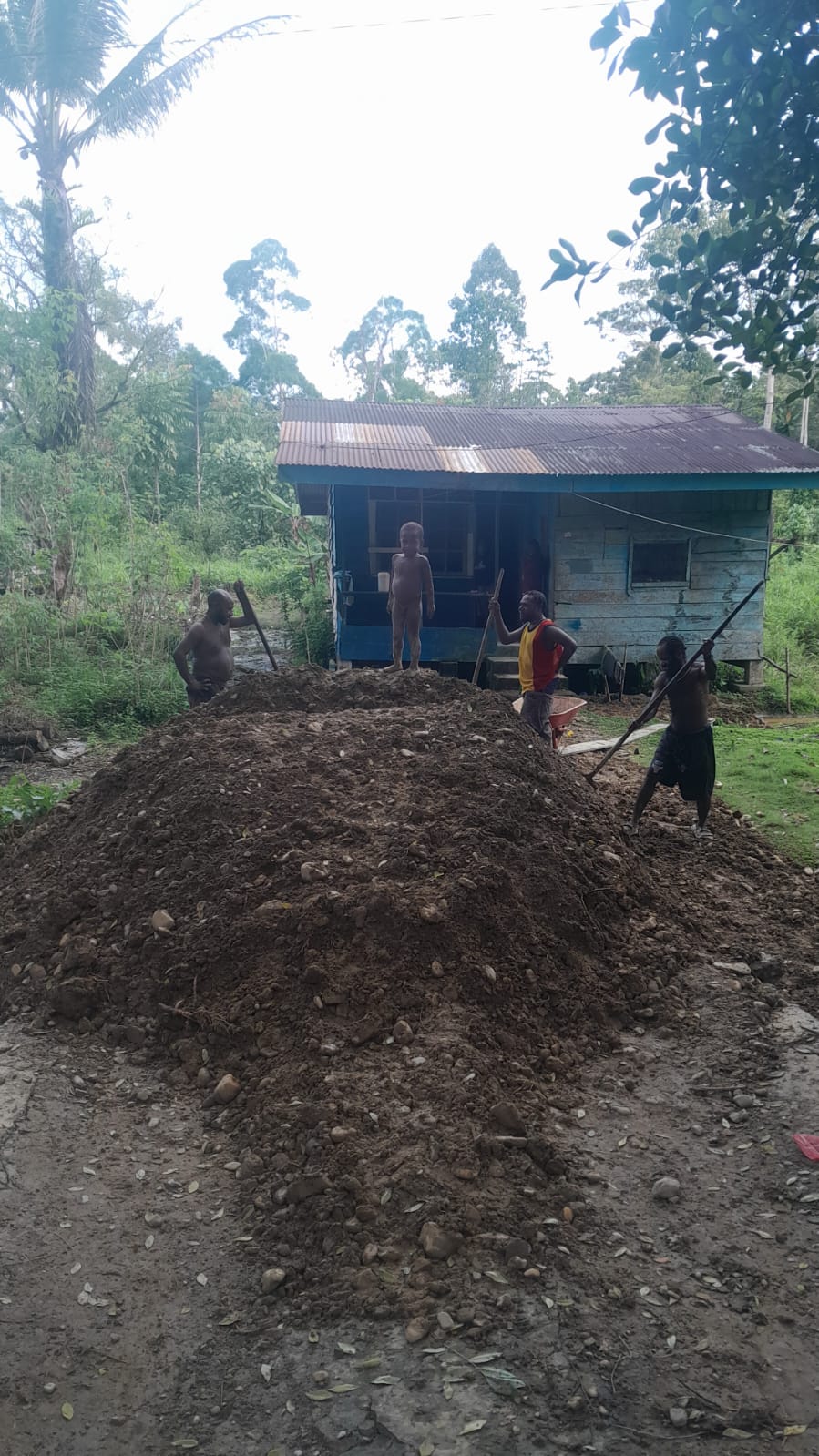 Warga saat merapikan timbunan yang berada didepan rumah