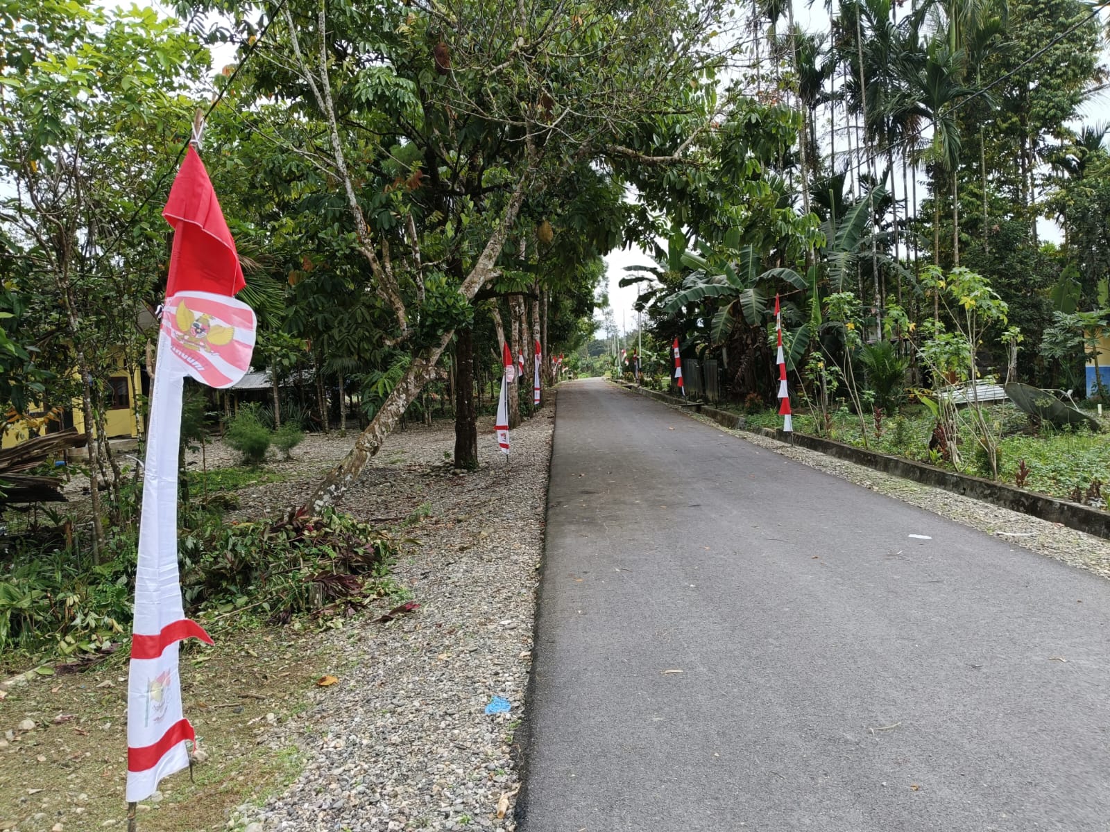 Jalan masuk menuju Kampung Karya Kencana yang telah  bersih dan dipasang umbul-umbul 