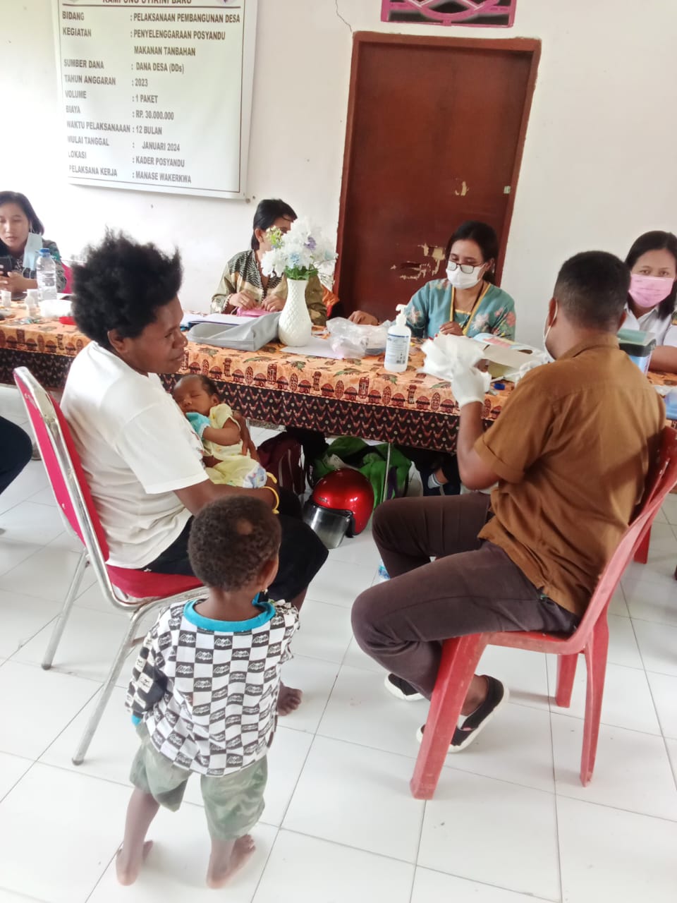 Seorang ibu saat membawa anaknya ke posyandu 