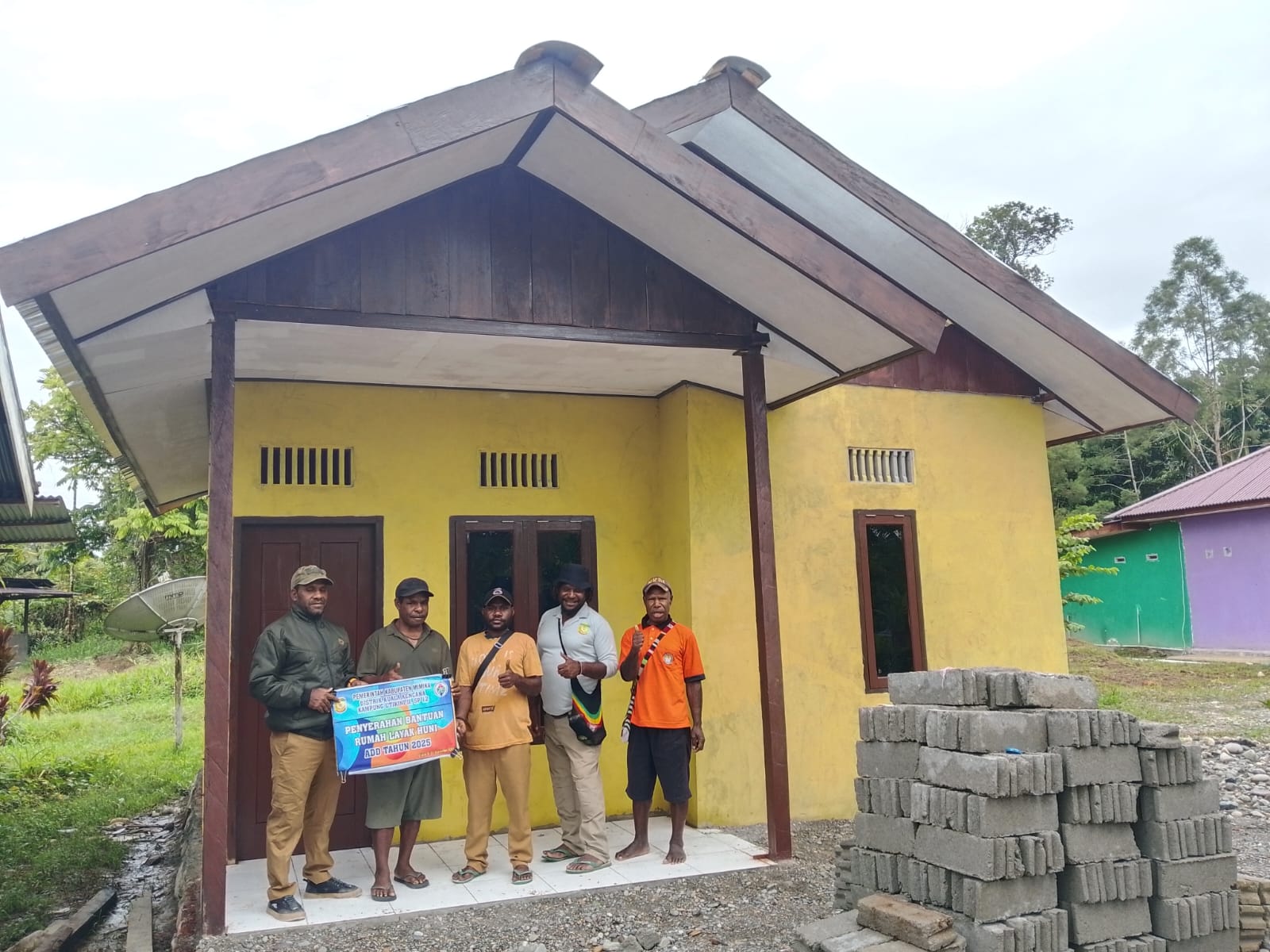Foto bersama Kepala Kampung Utikini II, Marinus Kogoya, Sekertaris Kampung Utikini II, Naton Murib, dan warga yang menerima kunci rumah