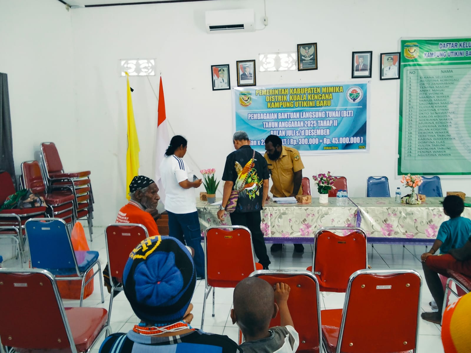 Kepala Kampung Utikini I, Luther Karagainal didampingi pendamping desa saat menyerahkan BLT kepada KPM