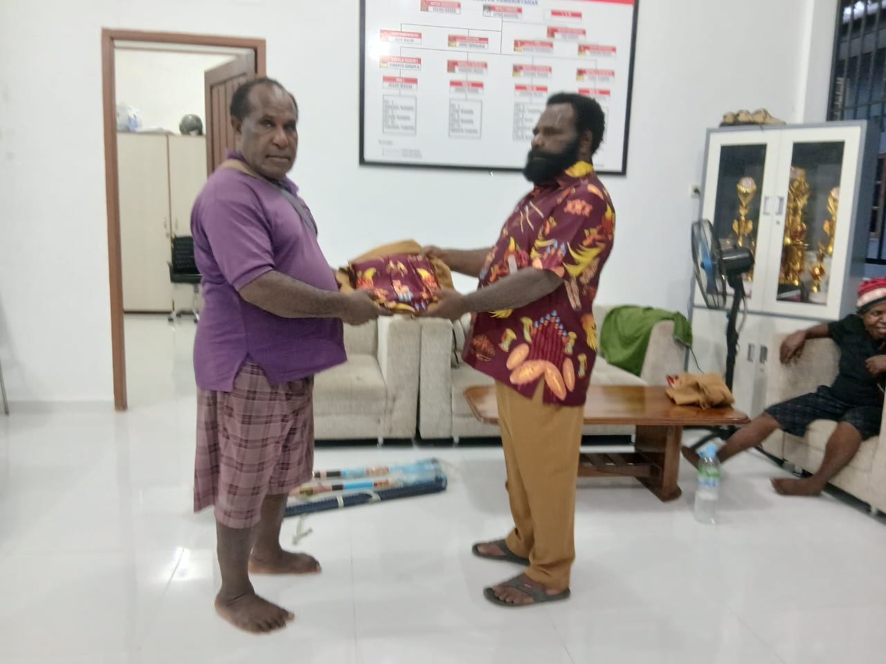 Kepala Kampung Utikini I saat menyerahkan kemeja kepada aparatur Kampung