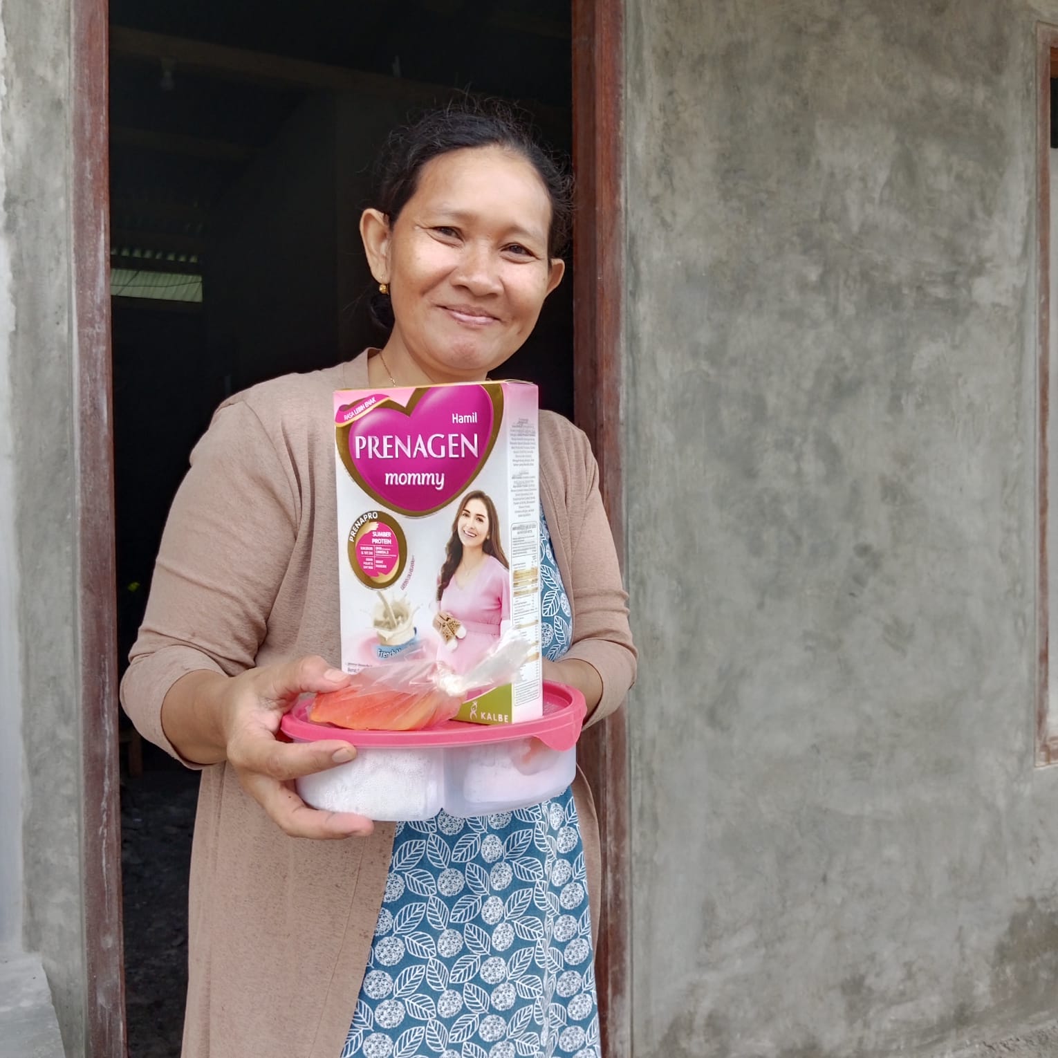 Seorang ibu hamil menerima makanan tambahan dan susu untuk ibu hamil