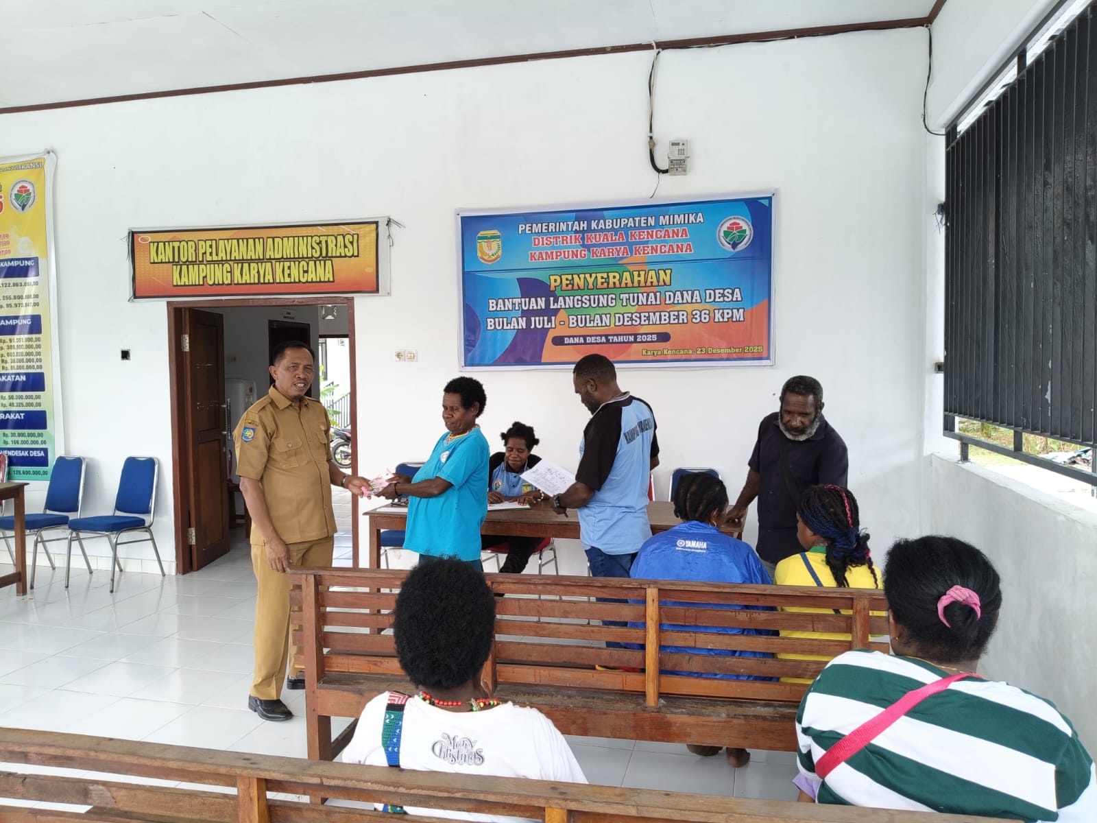Kepala Kampung Karya Kencana Rakam Suntoro saat menyerahkan BLT kepada warga 