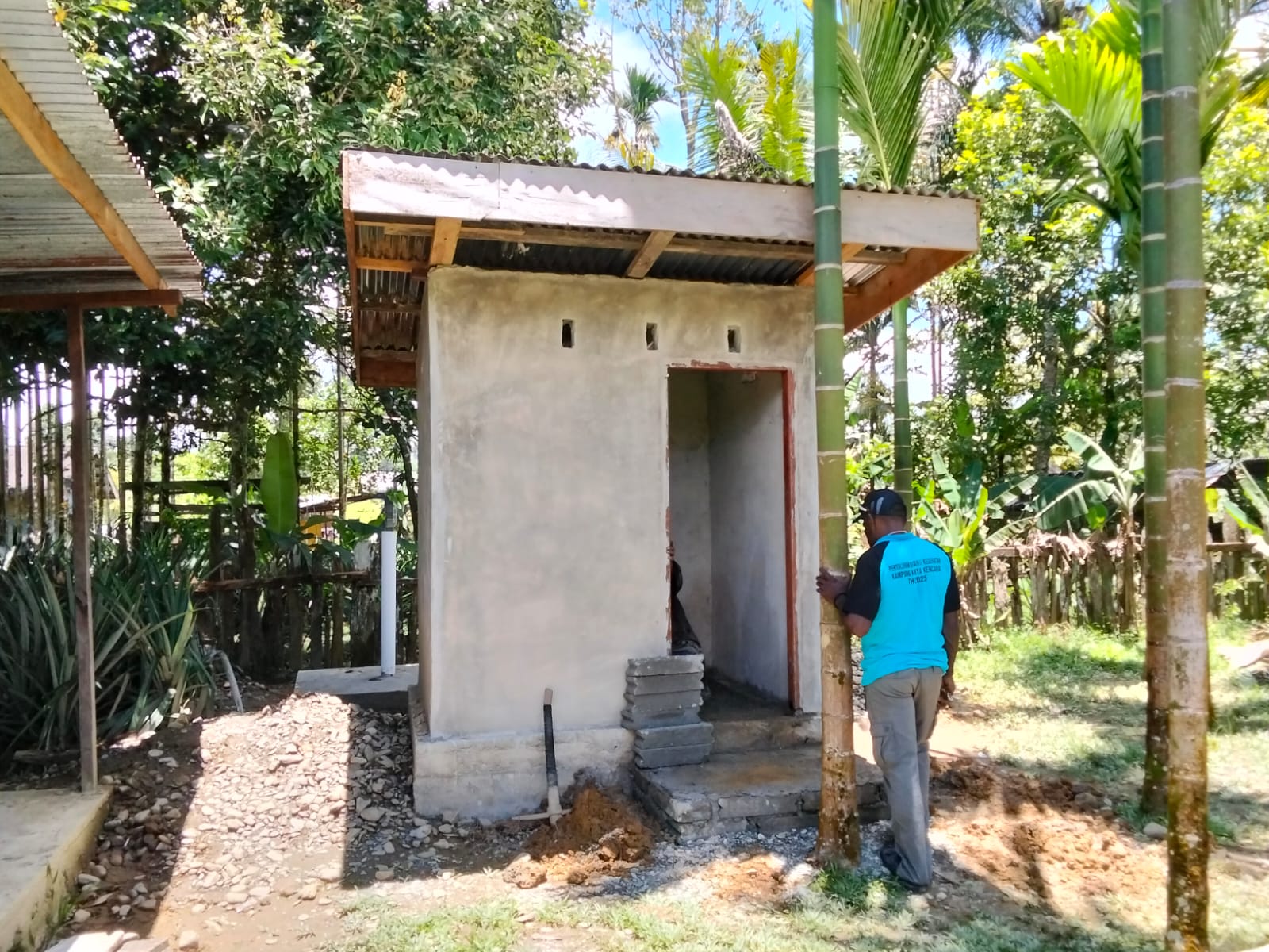 Kepala Kampung Karya Kencana, Rakam Suntoro saat meninjau pembangunan MCK