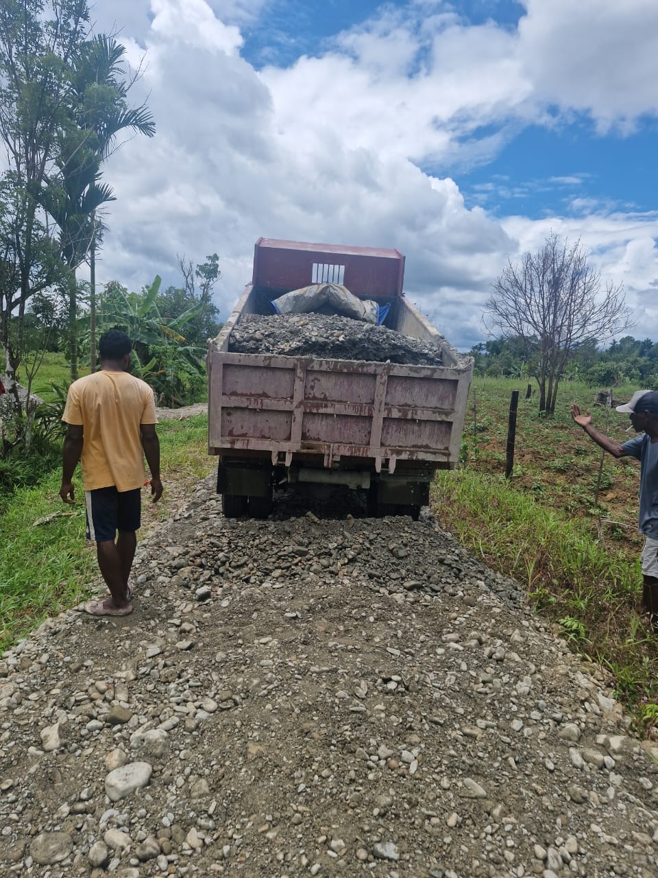 Truk pengangkut material saat menumpahkan material berupa galian c untuk menimbun jalan Kampung