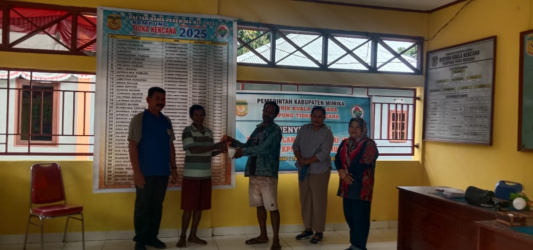 Bendahara Kampung Tioka Kencana Yotius Labene didampingi Sekertaris Kampung Tioka Kencana Andi Sahrul Akbar dan pendamping desa saat menyerahkan bantuan langsung tunai kepada warga