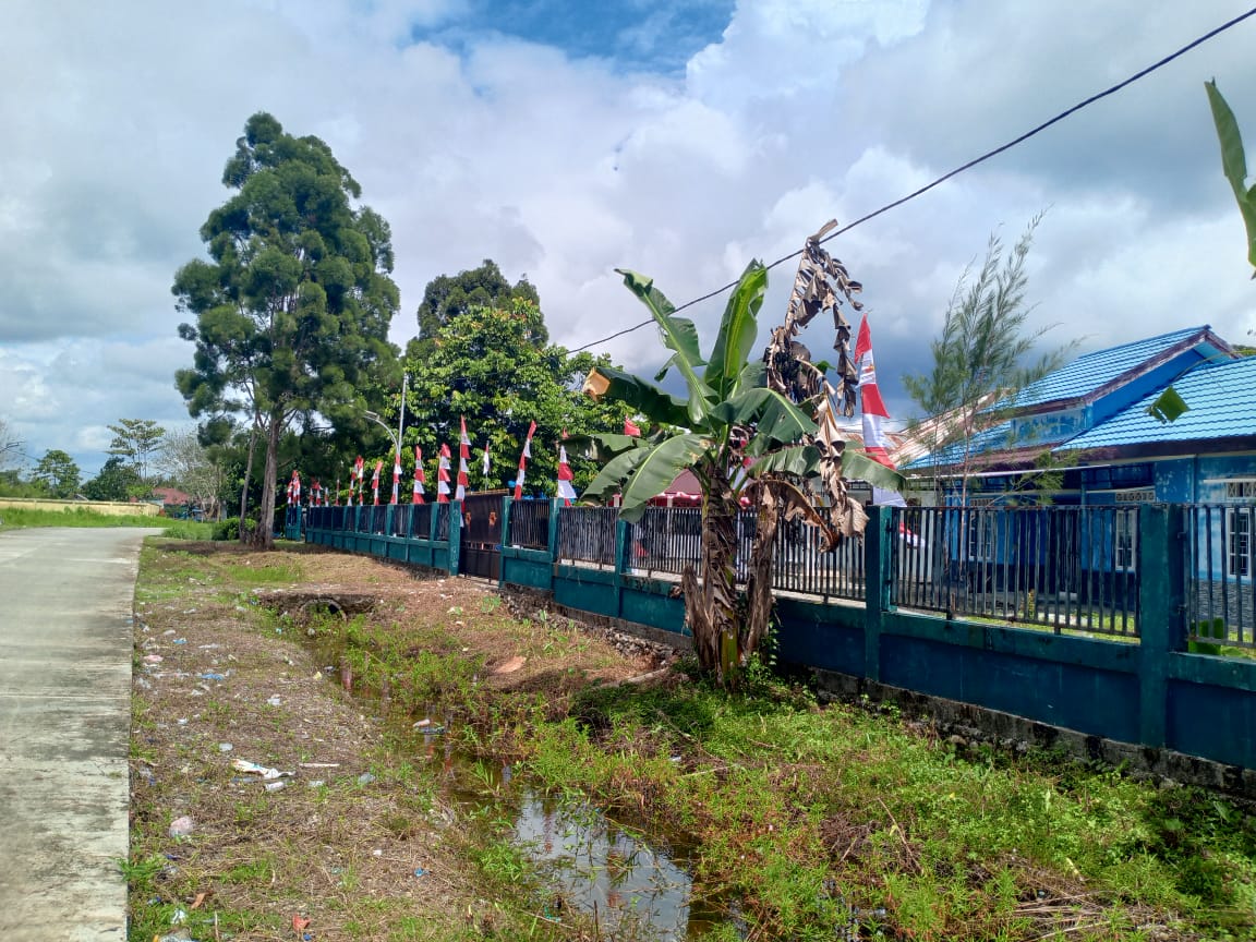 Warga Kampung Mimika Gunung sedang memasang umbul-umbul dipagar Kantor Kampung