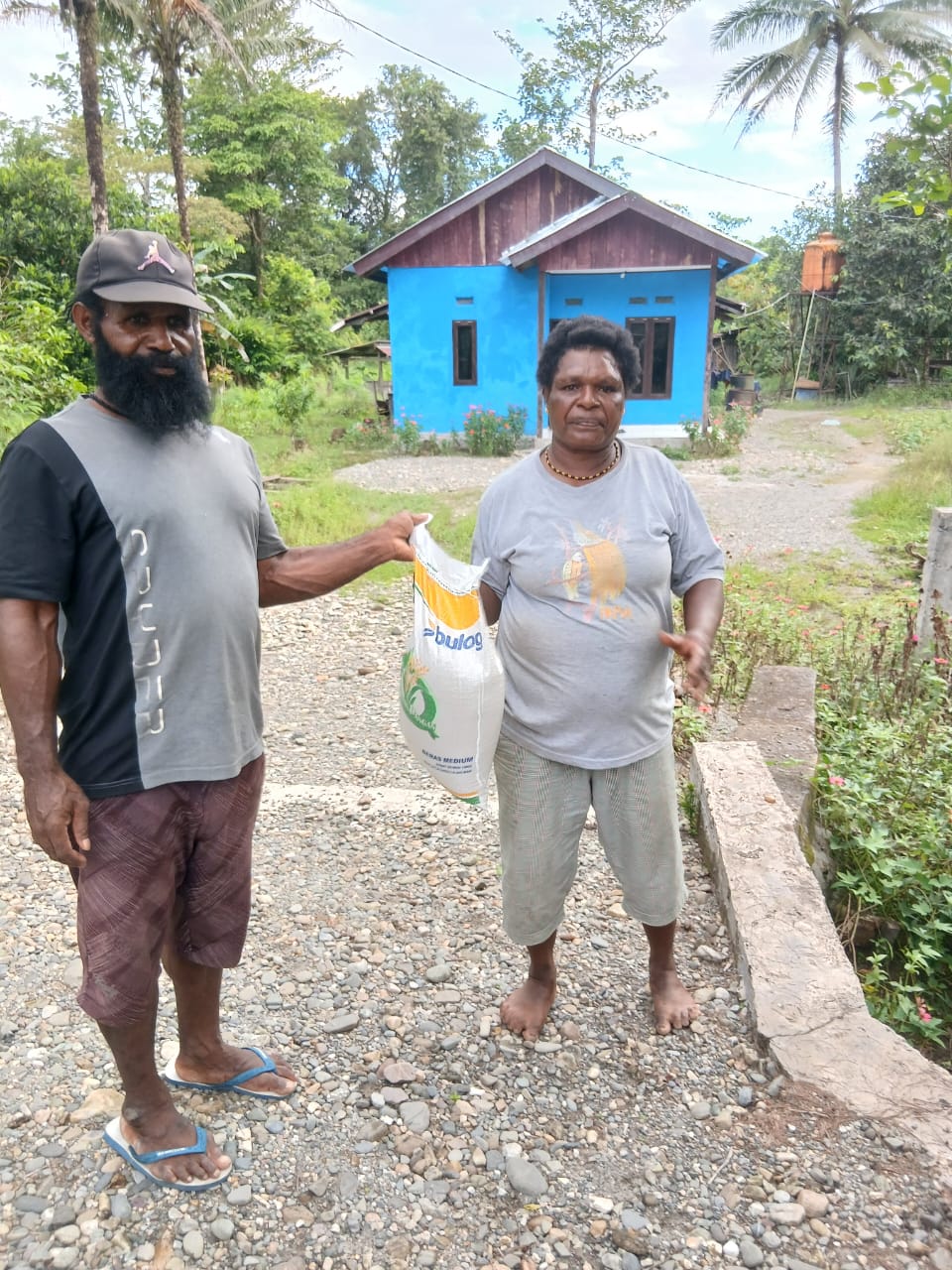 Aparatur Kampung Utikini I saat menyerahkan bantuan beras kepada warga